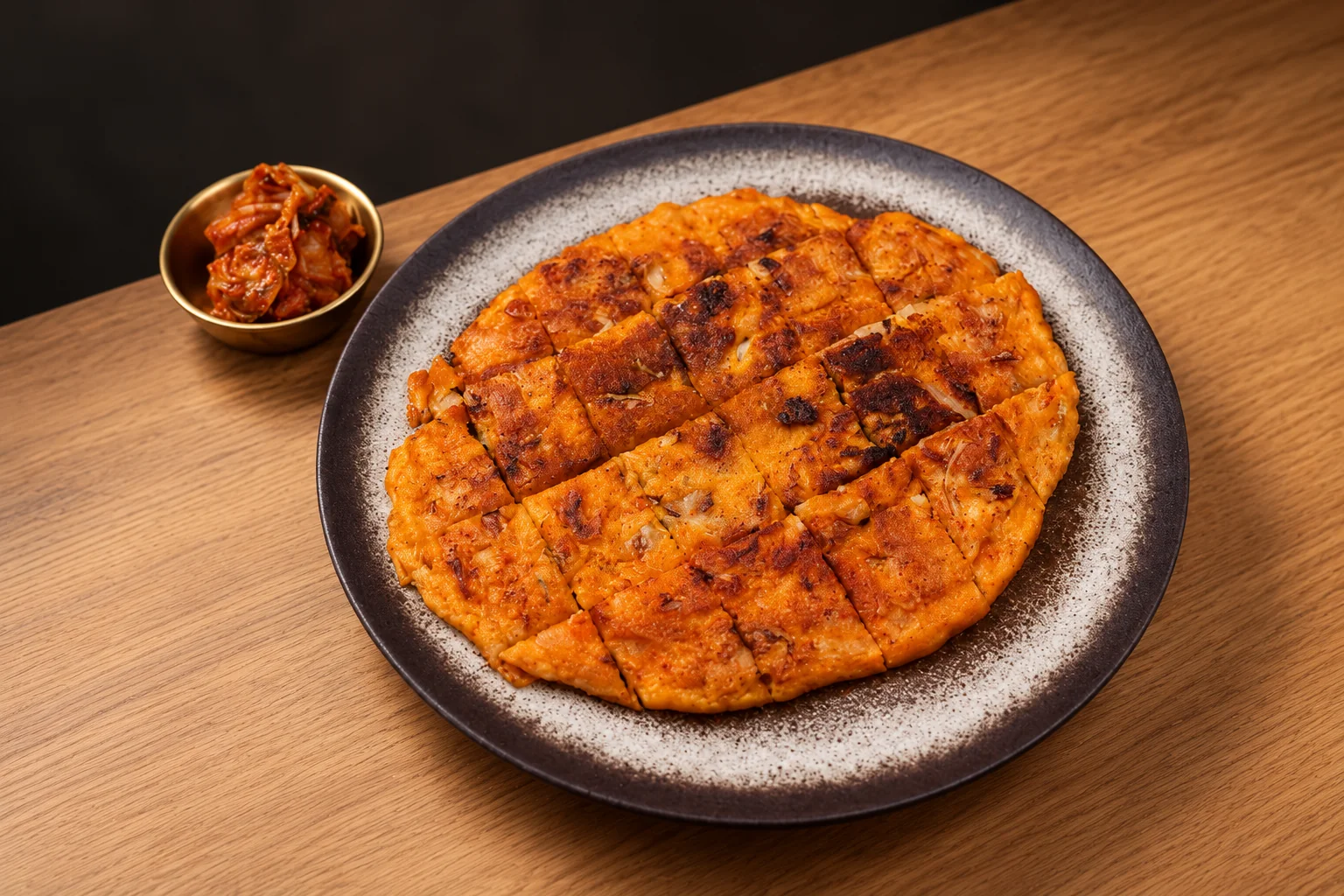 Kimchi pancake on a dark plate.